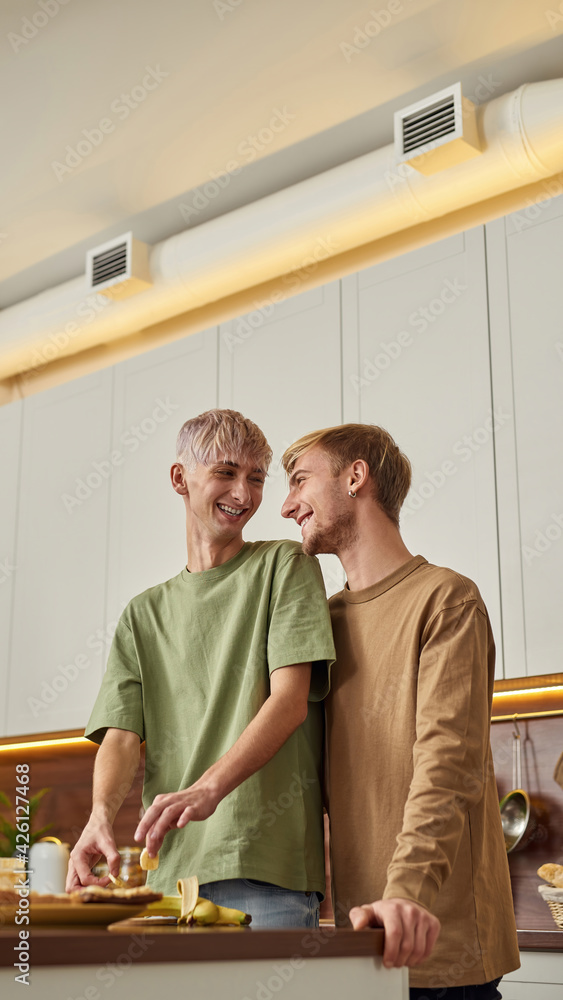 Smiling gay couple hugging each other and laughing Smiling gay couple hugging each other and laughing