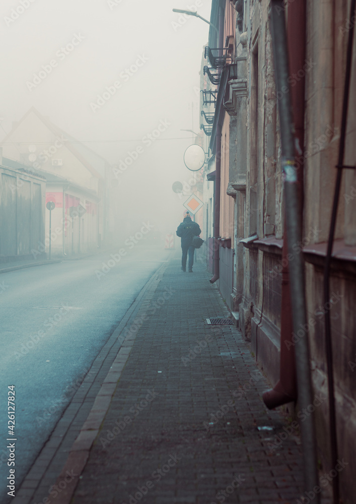 person at the misty streets of the small town