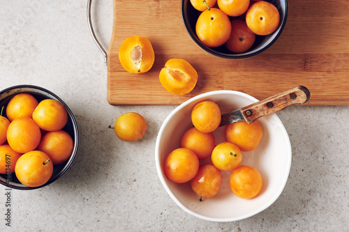 Ripe yellow mirabelle plums in bowls. photo