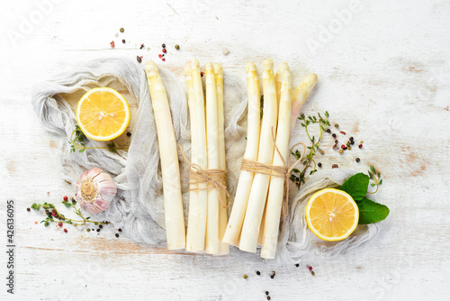 Organic white asparagus on a white wooden background. Healthy food. Top view. Free space for your text.