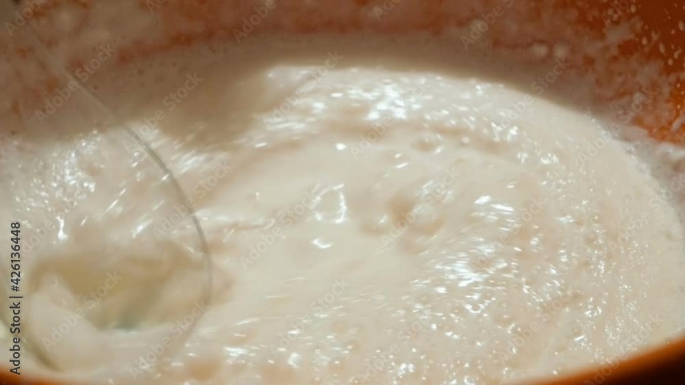 The chef whips organic milk cream with a blender. The chef whips organic milk cream with a blender.