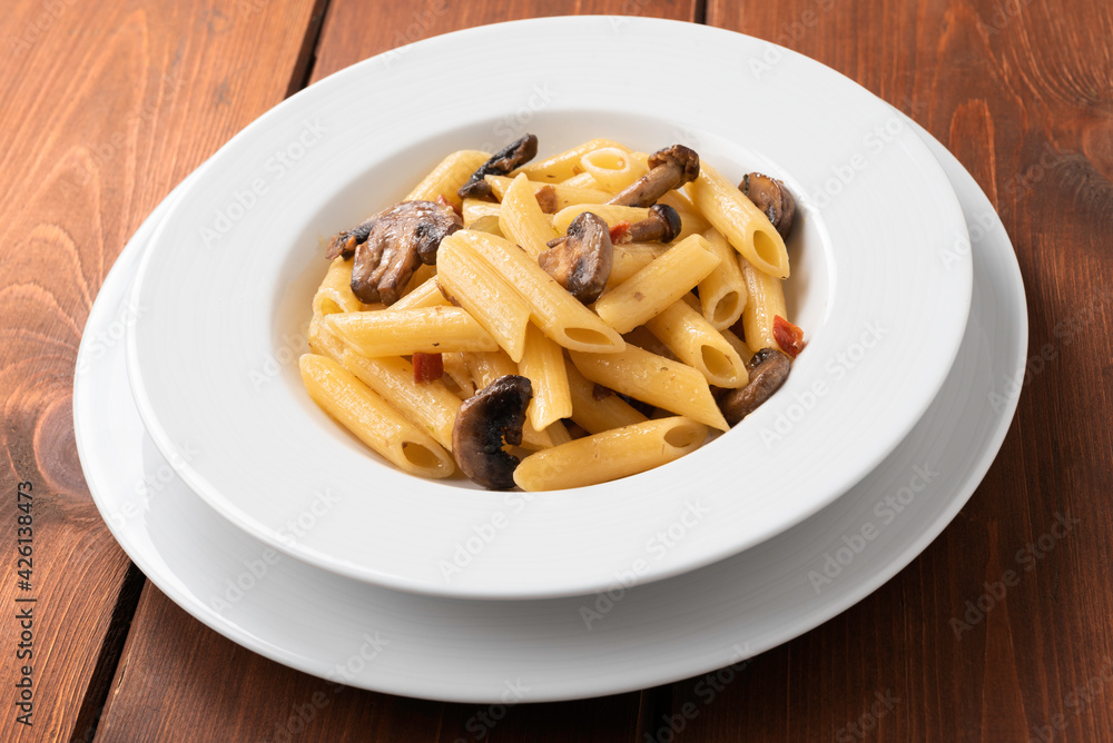 Piatto di deliziose penne condite con funghi e carote, Cucina Vegetariana Italiana Piatto di deliziose penne condite con funghi e carote, Cucina Vegetariana Italiana