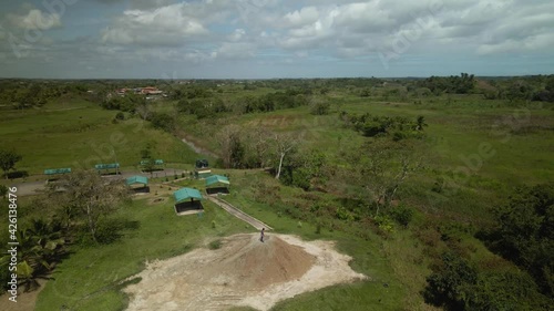 Aerial drone view of a young girl walking around the cone of a mud volcano located in Penal, Trinidad photo