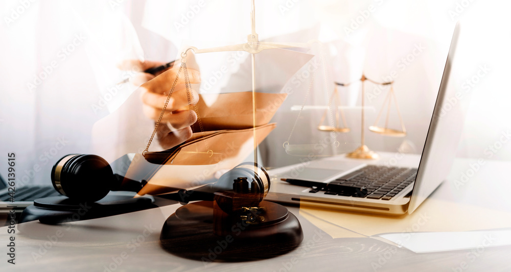 Business and lawyers discussing contract papers with brass scale on desk in office. Law, legal services, advice, justice and law concept picture with film grain effect Business and lawyers discussing contract papers with brass scale on desk in office. Law, legal services, advice, justice and law concept picture with film grain effect