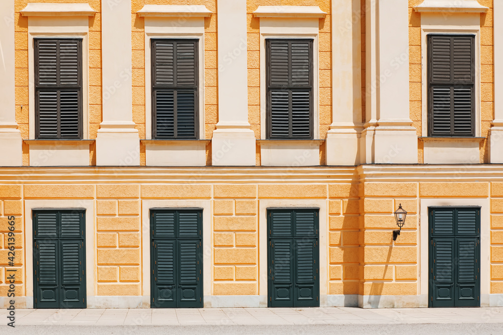 Close door and window shutters on the yellow facade