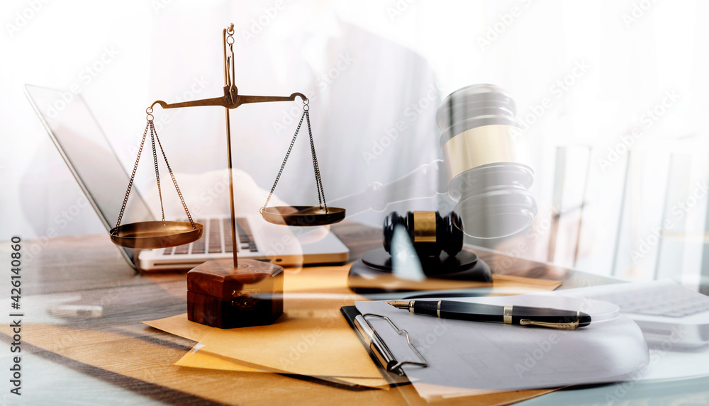 Business and lawyers discussing contract papers with brass scale on desk in office. Law, legal services, advice, justice and law concept picture with film grain effect Business and lawyers discussing contract papers with brass scale on desk in office. Law, legal services, advice, justice and law concept picture with film grain effect