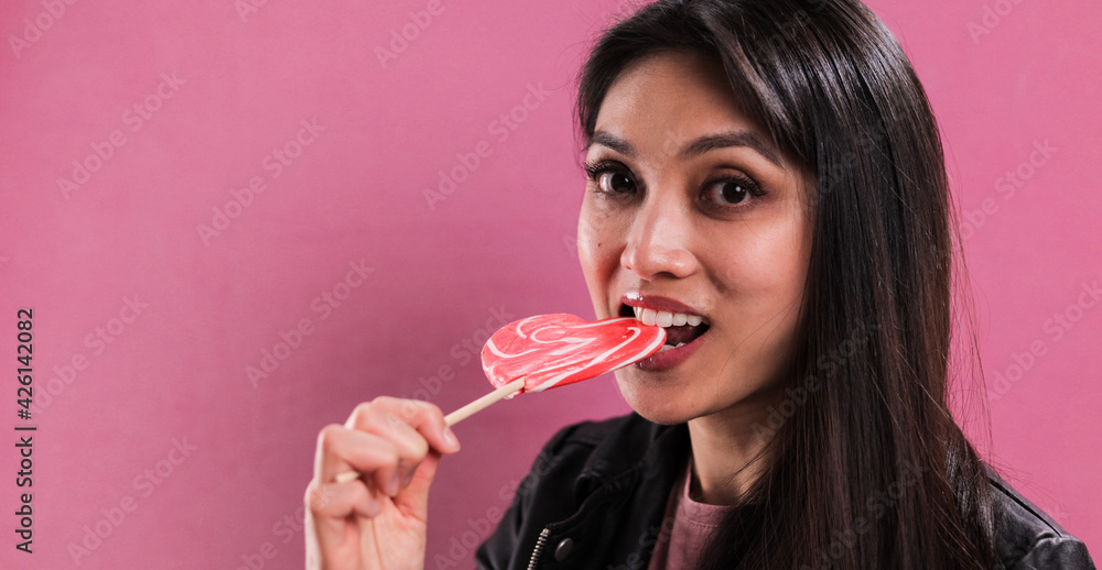 Young pretty woman licks a big lollipop - studio photography Young pretty woman licks a big lollipop - studio photography