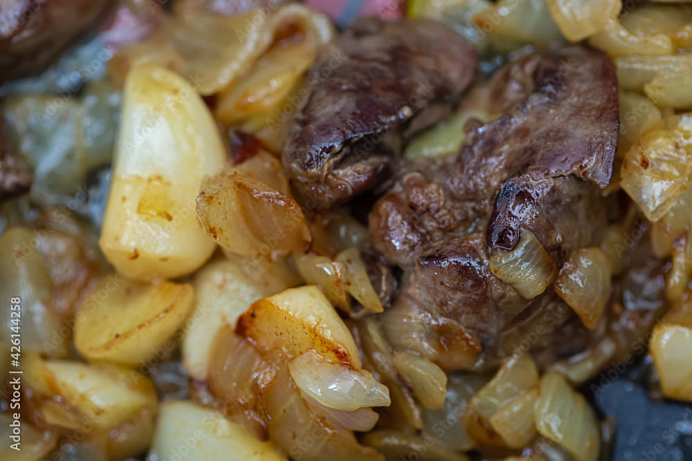 Fried chicken liver and garlic, onions in a pan. The food is cooked. Shallow depth of field. Top view. Fried chicken liver and garlic, onions in a pan. The food is cooked. Shallow depth of field. Top view.