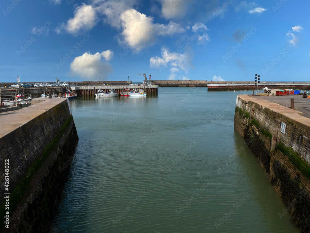 Port-en-Bessin-Huppain, France, March 2021. Picture made of sailing channel towards the sea in a picturesque small town in Normandy