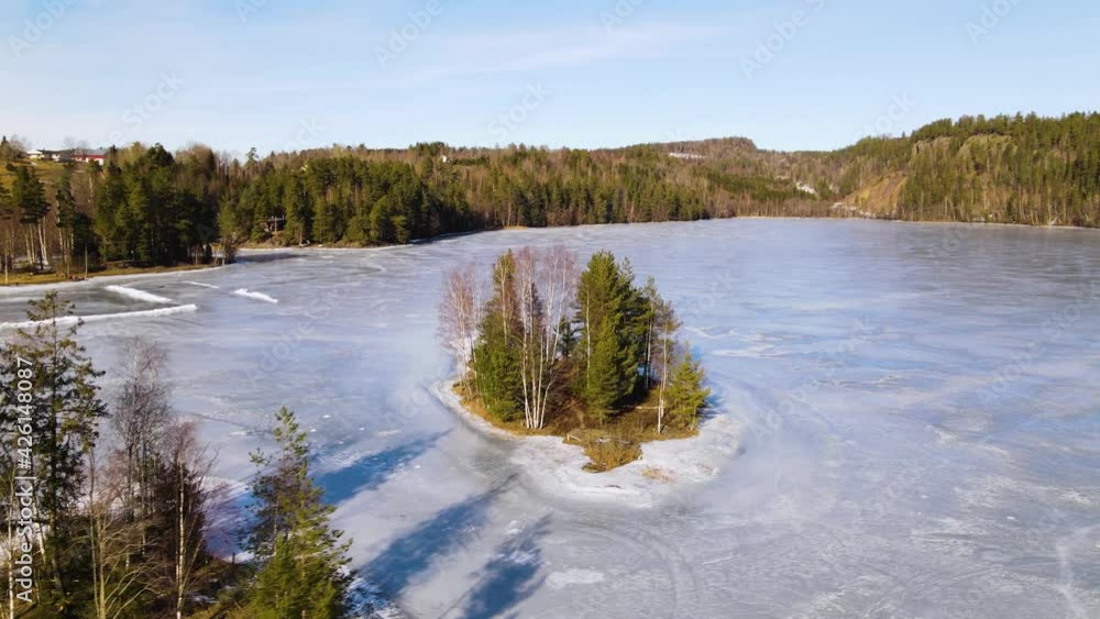 Aerial shot of an icy Norwegian lake with two islands 4k Aerial shot of an icy Norwegian lake with two islands 4k
