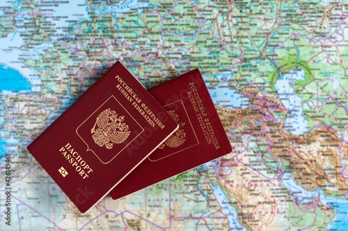 Two Russian passports against the background of a geographic map.
