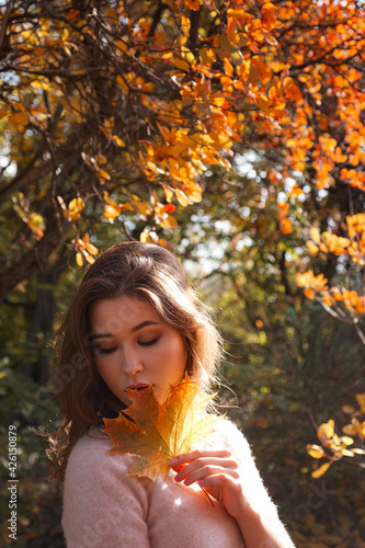 Beautiful young woman walking in the autumn forest