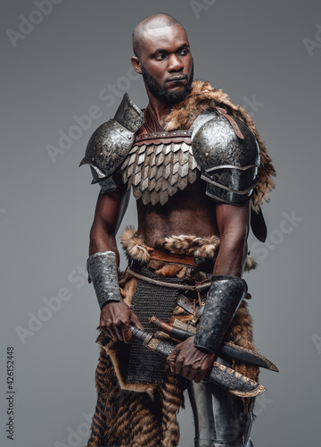 Wild ancient soldier with shaved head and black skin with a blade