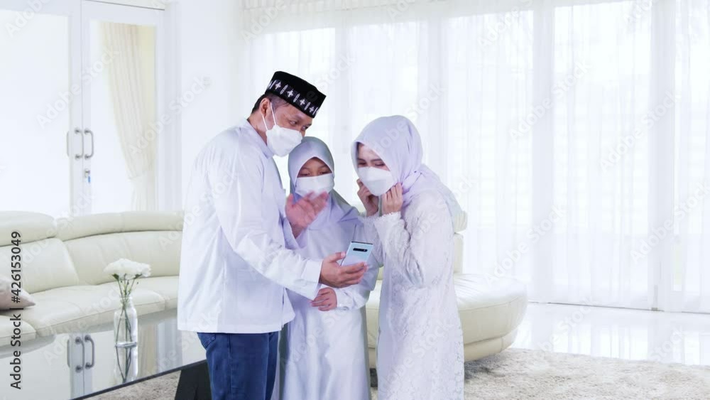 Muslim parents and child in mask making video call Muslim parents and child in mask making video call