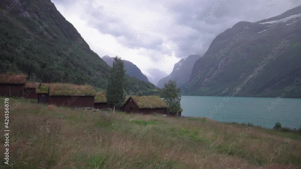 Old cabins at Loen lake and mountain ladscape in Norway, bad weather on a beautiful location Old cabins at Loen lake and mountain ladscape in Norway, bad weather on a beautiful location