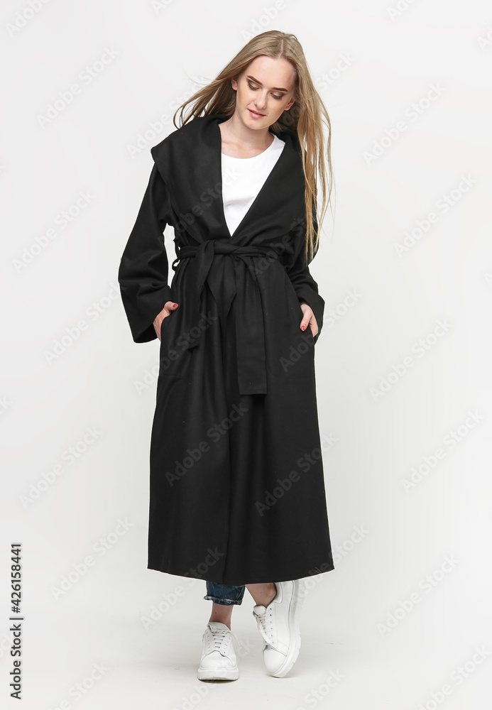 beautiful model posing in a black long coat on a white background. studio shot. Clothing advertising concept beautiful model posing in a black long coat on a white background. studio shot. Clothing advertising concept