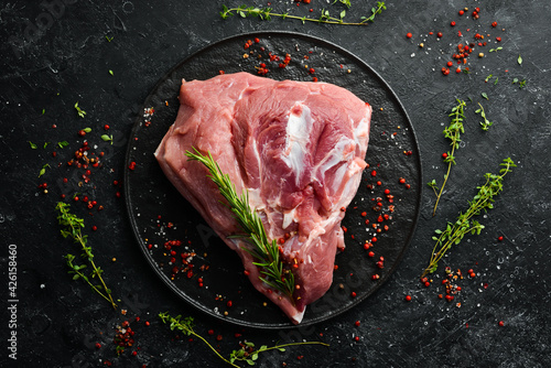 fresh raw pork shoulder with ingredients and spices on kitchen background. Meat. Top view. Rustic style.