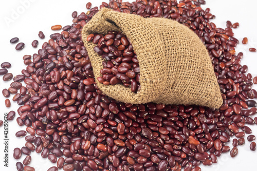 Fresh organic red kidney beans or rajma in a sackcloth bag on white background. photo