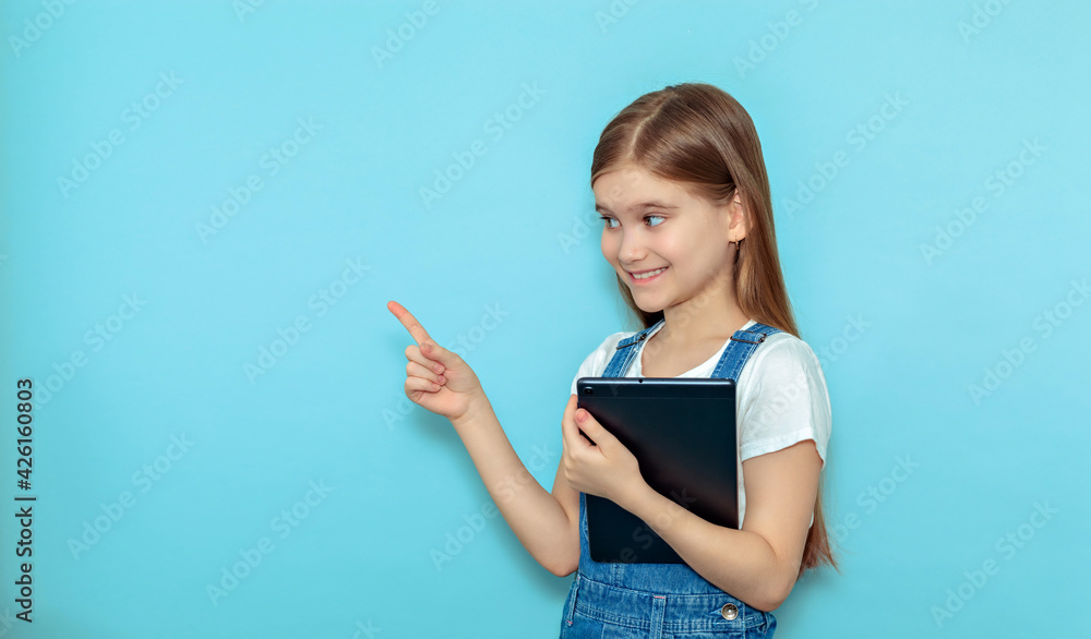Horny teen girl with tablet pointing finger isolated on blue background Horny teen girl with tablet pointing finger isolated on blue background