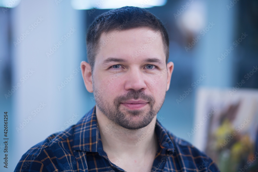 Portrait of a young man in a shirt and jeans indoors. Portrait of a young man in a shirt and jeans indoors.