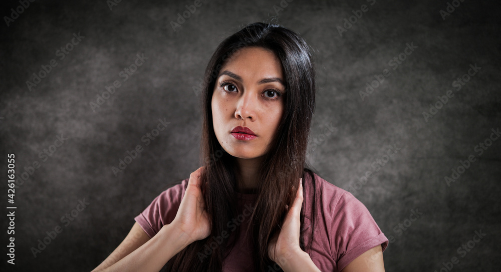 Pretty Asian woman against a grey background - studio photography Pretty Asian woman against a grey background - studio photography