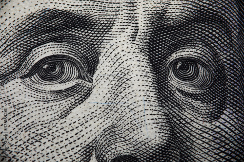 Close-up of benjamin franklins face on hundred banknote photo