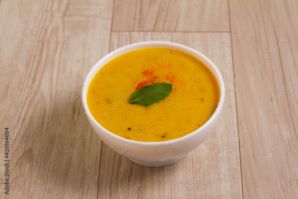 Indian Cuisine Kadhi - Vegetarian Curry Made of Buttermilk And Chick Pea Flour. served in a bowl or Karahi over wooden background, selective focus