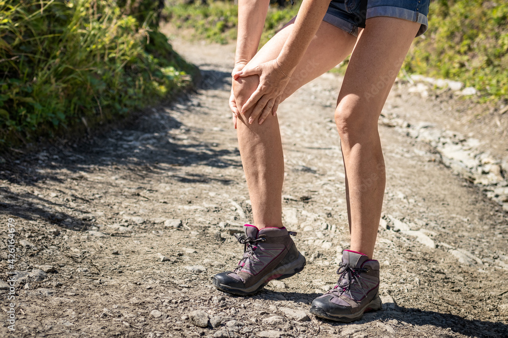 Tourist injured during hike. Woman feeling knee pain. Female hiker having health problem Tourist injured during hike. Woman feeling knee pain. Female hiker having health problem