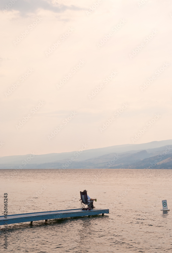 A man relax sitting on pier.