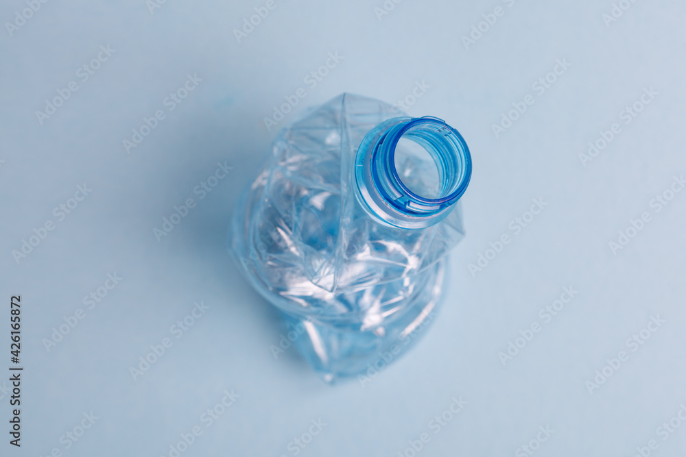 Used crushed plastic bottle on blue background top view, recycling and environment concept Used crushed plastic bottle on blue background top view, recycling and environment concept