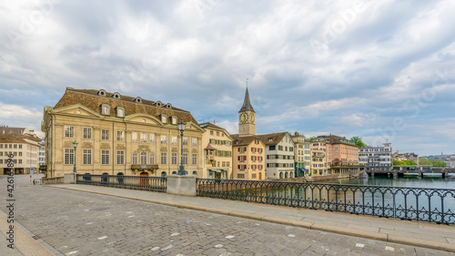 Beautiful view of historic city center of Zurich with famous Fraumunster Church and Munsterbucke crossing river Limmat on a sunny day with blue sky and clouds in summer, Canton of Zurich, Switzerland © karamysh