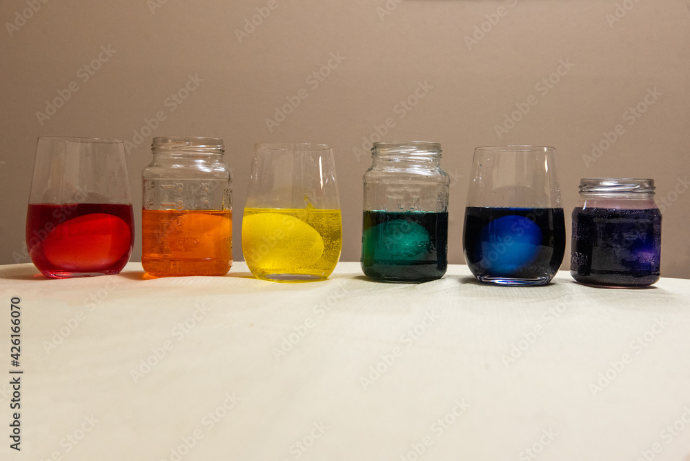 Eggs sit on different glasses of dye for Easter. Eggs sit on different glasses of dye for Easter.