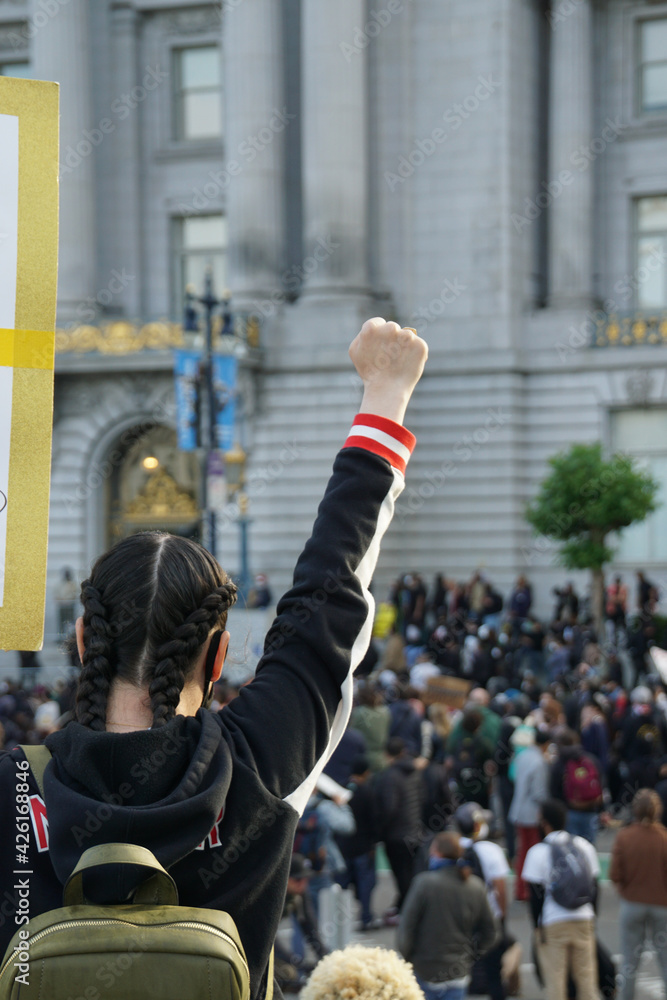 Vertical shot of a female with a clenched fist during the Black Lives Matter protest - obrazy, fototapety, plakaty 