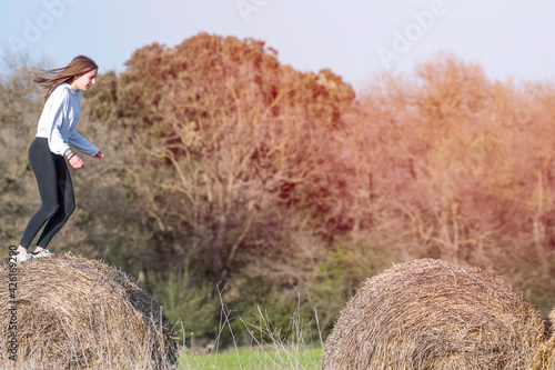 Wallpaper Mural latina teenage girl posing on top of straw bales in rural setting, lifestyle Torontodigital.ca