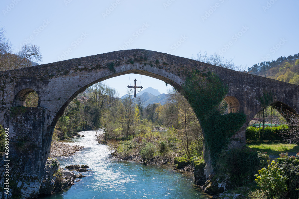 Ancient roman bridge at Cangas de Onis, Asturias, with a cross hanging from it as a symbol of victory