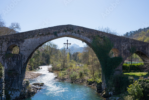 Ancient roman bridge at Cangas de Onis, Asturias, with a cross hanging from it as a symbol of victory