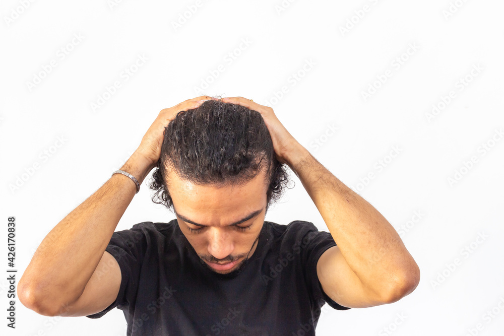 Fototapeta premium Black man with black t-shirt on white background passing cream on hair