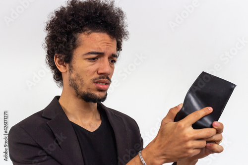Black man with black t-shirt and blazer on white background sad with empty black wallet