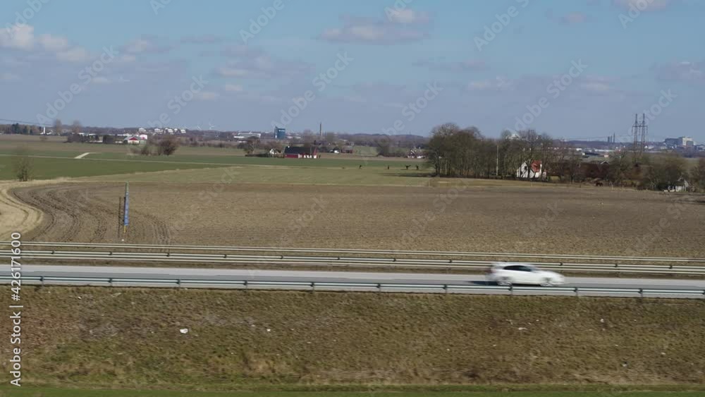 Drones fly next to a freeway with traffic in spring Drones fly next to a freeway with traffic in spring