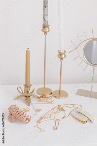 Boho accessory, interior details. Modern gold jewellery, hair clips with vintage candles and mirror