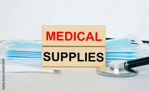 Wooden blocks with text Medical Supplies lying with the mask, stethoscope and thermometer