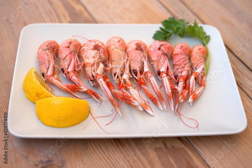 boiled crayfish, with oil and lemon sauce, on a plate, karavides in Greek photo