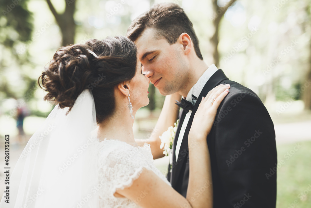 Happy wedding couple charming groom and perfect bride posing in park Happy wedding couple charming groom and perfect bride posing in park