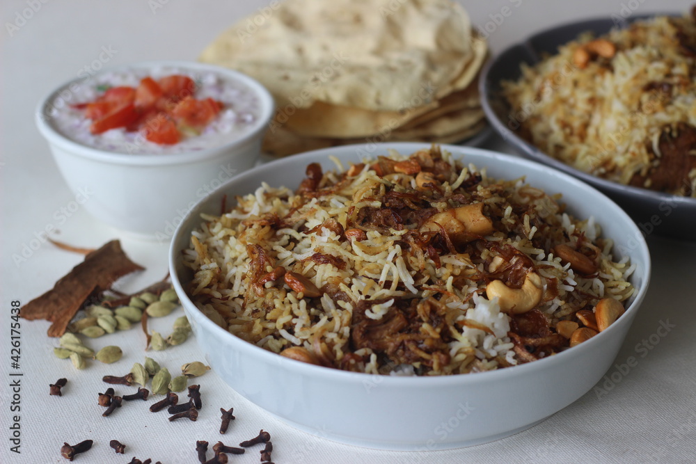 Mutton Biryani. A dish cooked with spices layered between mildly spiced ghee rice with a generous sprinkle of caramelized onions and Mutton marinated in yogurt Mutton Biryani. A dish cooked with spices layered between mildly spiced ghee rice with a generous sprinkle of caramelized onions and Mutton marinated in yogurt