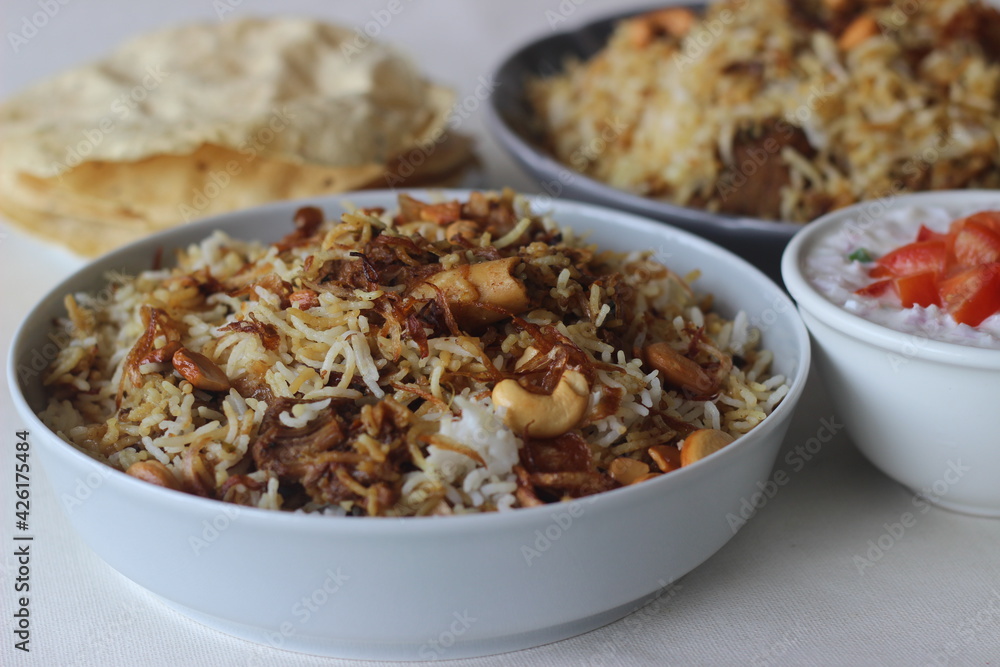 Mutton Biryani. A dish cooked with spices layered between mildly spiced ghee rice with a generous sprinkle of caramelized onions and Mutton marinated in yogurt Mutton Biryani. A dish cooked with spices layered between mildly spiced ghee rice with a generous sprinkle of caramelized onions and Mutton marinated in yogurt