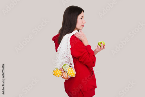 Woman holding cotton shopper  and mesh shopping bag With fruit on beige background. Eco friendly mesh shopper. Zero waste concept