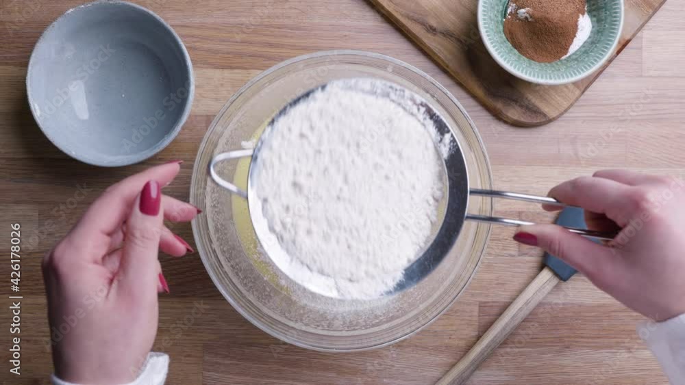 Baker Sifting Flour Through Fine Mesh Sieve For Cake Dough. - Top Down Shot Baker Sifting Flour Through Fine Mesh Sieve For Cake Dough. - Top Down Shot