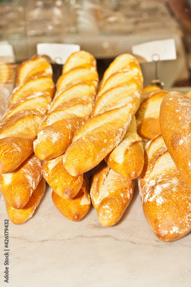 top, front view, medium distance of loaves of freshly baked French bread, on display and for sale at a tropical farmers market
