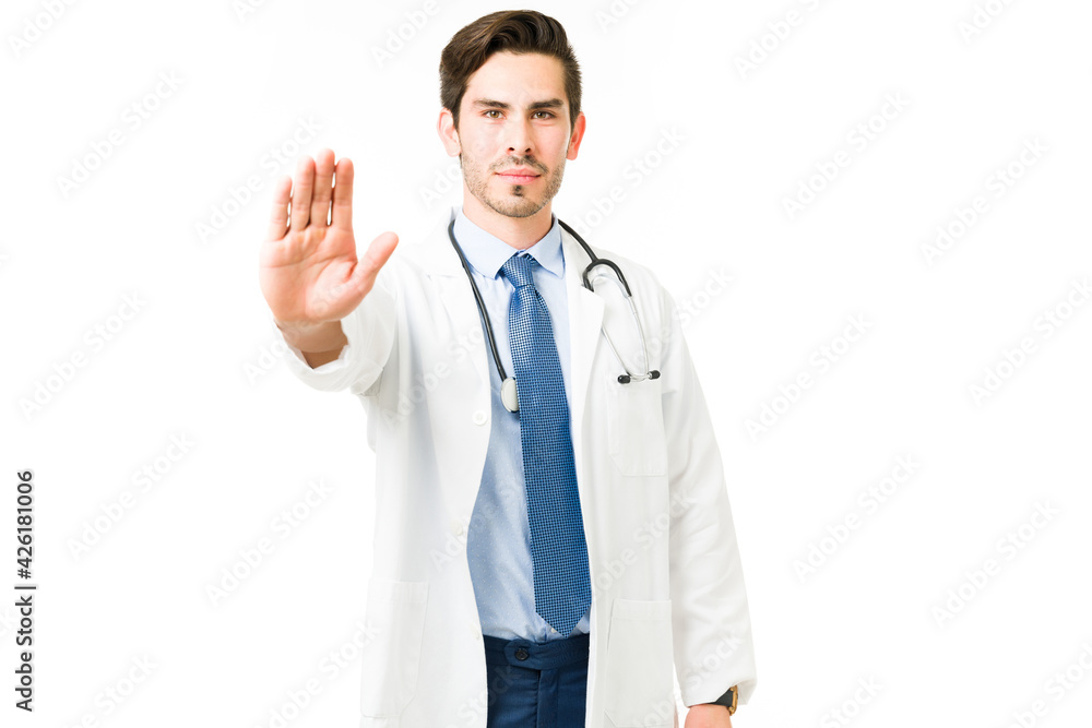 Professional doctor holding up his hand and stopping Professional doctor holding up his hand and stopping