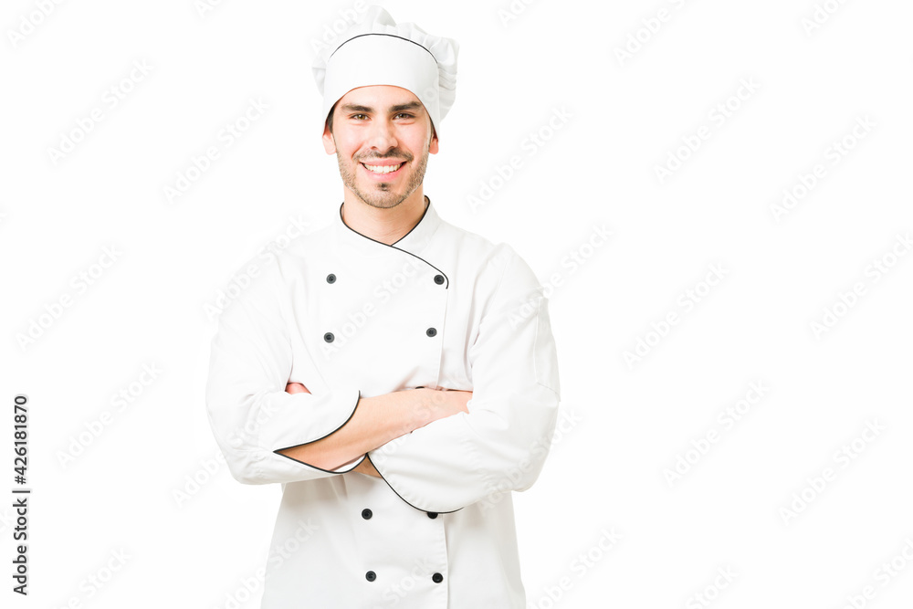 Good-looking cook smiling and posing in a white background